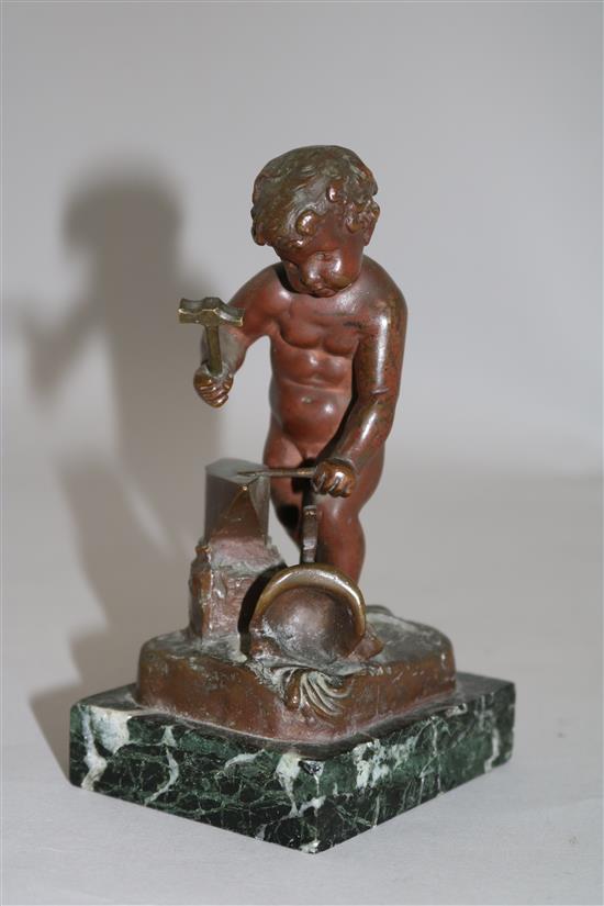 Henri Capy. A bronze figure of a putto forging an arrow, 6in.